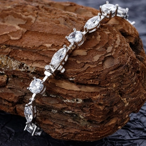 Dettaglio macro del bracciale in argento con cristalli su corteccia ruvida