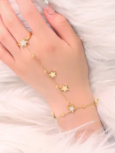 Detailed shot of a gold star hand harness with star pendants on white faux fur background