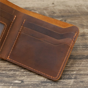 Vintage brown crazy horse leather wallet with internal card slots on rustic wood