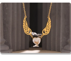 Close-up of golden angel wing necklace featuring a heart-shaped zircon and a Roman column