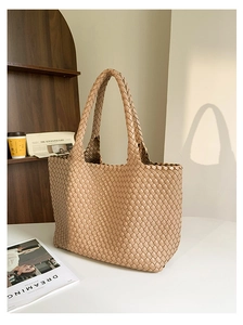 Detailed view of the intricate beige leather weave and texture on a large tote bag
