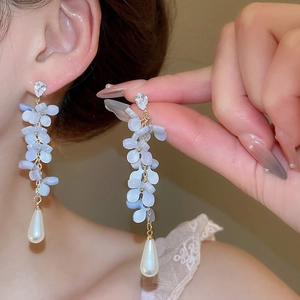 Macro detail of elegant flower earrings with crystal petals and water drop pearl fringe
