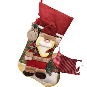 Large red burlap Christmas stocking featuring a 3D Santa Claus figure for festive holiday decor