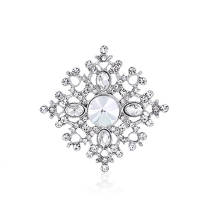 Detail of silver-tone snowflake brooch with centered crystal and shimmering pavé rhinestones