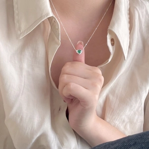 Close-up of heart-shaped green crystal pendant on 925 sterling silver chain necklace