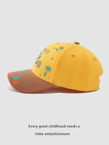 Close-up of children's baseball cap featuring cartoon dinosaur and palm tree embroidery