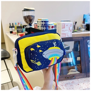 Detail of blue and yellow canvas crossbody bag with UFO cartoon and rainbow strap