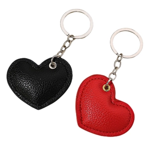 Pair of heart-shaped PU leather keychains in black and red with metal rings and stitching