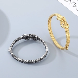 Close-up of gold and silver knotted bangles showing fine twisted metal textures