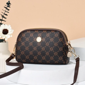 Elegant brown leather crossbody bag with rose floral pattern on layered display stands