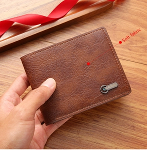 Gros plan sur un portefeuille pour homme en cuir marron texturé avec logo en métal détaillé