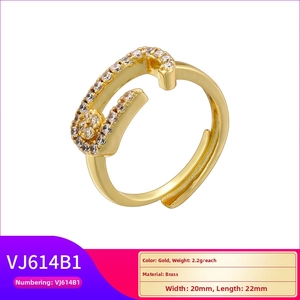 Detailed view of a gold safety pin ring in brass set with white cubic zirconia stones