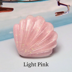 Gros plan d'un coquillage en résine rose avec paillettes et texture nervurée 3D