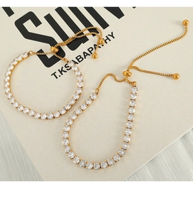 Detail of adjustable gold tennis bracelets with sparkling zircons on a book cover