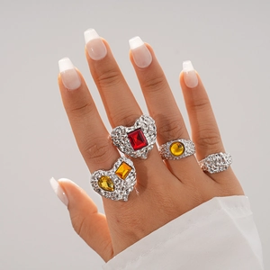 Close-up of four chunky textured silver rings with red and yellow resin heart stones