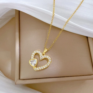 Gros plan du pendentif cœur doré serti de cristaux sur un coffret à bijoux