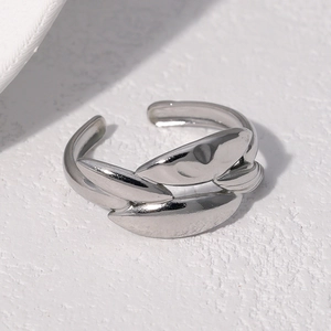 Macro detail of silver adjustable ring featuring overlapping leaf-like metal layers