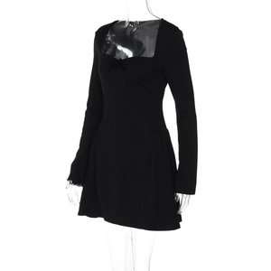 Détail de robe courte noire à encolure carrée avec nœud frontal et manches