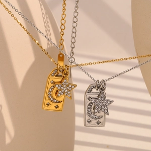 Detail of gold and silver square pendants with moon star relief and crystal accents