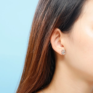 Close-up of S925 sterling silver four-leaf clover stud earrings worn by a model