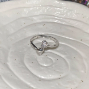 Macro detail of silver heart ring featuring sparkling pavé zircon and polished metal finish