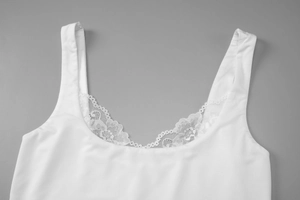 Détail de la dentelle blanche sur un débardeur court ajusté sans manches