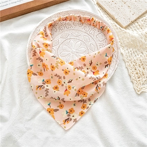 Detail of floral print triangular headband with elastic back on white embossed tray