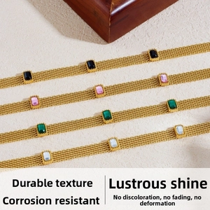 Détail de bracelets en maille dorée avec des pierres rectangulaires colorées sur pierre