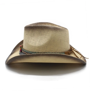 Detail of vintage straw cowboy hat featuring ethnic beaded band and rustic fringe accents