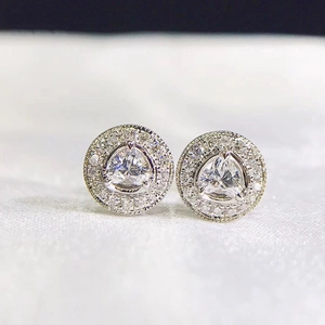 Detail of silver round stud earrings featuring a triangular zircon center and halo diamonds