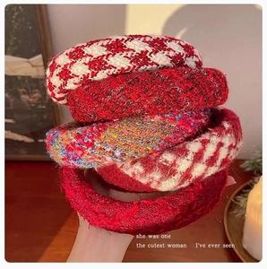 Detail of five assorted thick tweed and houndstooth texture headbands in festive red tones