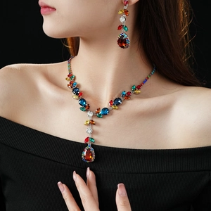 Close-up of vintage silver necklace and earrings set with red teardrop zircon stones