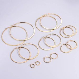 Set of 8 pairs gold stainless steel hoop earrings in various sizes on white background