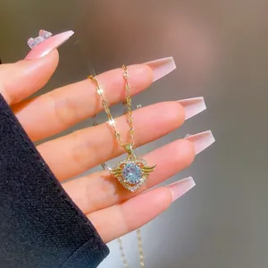 Detail view of gold Angel Heart necklace with crystal zircon and delicate wings