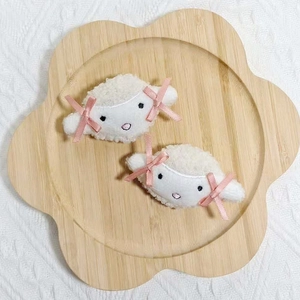 Barrettes peluche blanche avec nœuds roses sur plateau en bois en forme de fleur