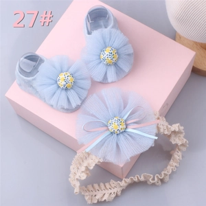 Detail of baby socks and lace headband set with light blue floral mesh ornaments