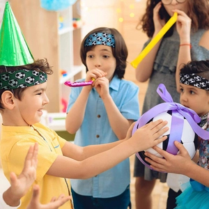 Kids celebrating with soccer headbands and a gift-wrapped football in a birthday party