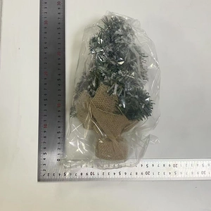 Miniature artificial Christmas tree with snow effect and burlap base with ruler measurement