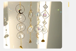 Close-up of golden metal sun catchers with transparent quartz and crystal ball charms
