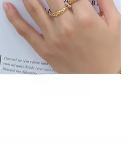 Close-up of golden titanium steel ring with textured woven pattern on a model's finger