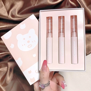 Three-piece glossy lip glaze set in a pink bear gift box with a silk background