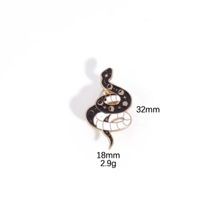 Detail view of black enamel snake brooch with gold moon and star patterns, 32mm size