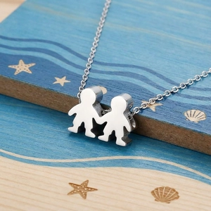 Detail showing two silver figures holding hands pendant on polished stainless steel necklace