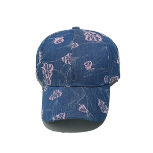 Close-up of structured denim baseball cap featuring textured 3D floral embroidery