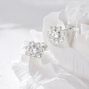 Detailed macro view of S925 sterling silver flower earrings with sparkling cubic zirconia