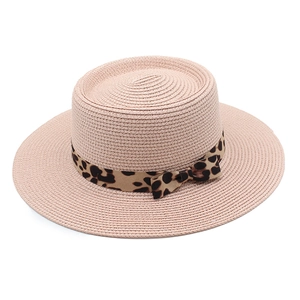Detail of pink straw boater hat featuring a leopard print ribbon and side bow accent