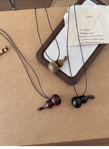 Détails de colliers en bois faits main en forme de gourde, tons brun, rouge et noir