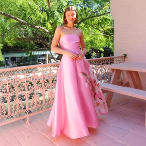 Nahaufnahme des rosa Satin-Abendkleides mit Blumendruck und hohem Taillenschnitt