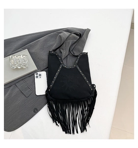 Close-up of black bohemian bag featuring fringe tassels and metal rivet decorations