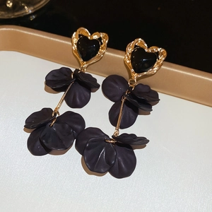 Detail of heart stud and tiered black flower petals on vintage drop earrings